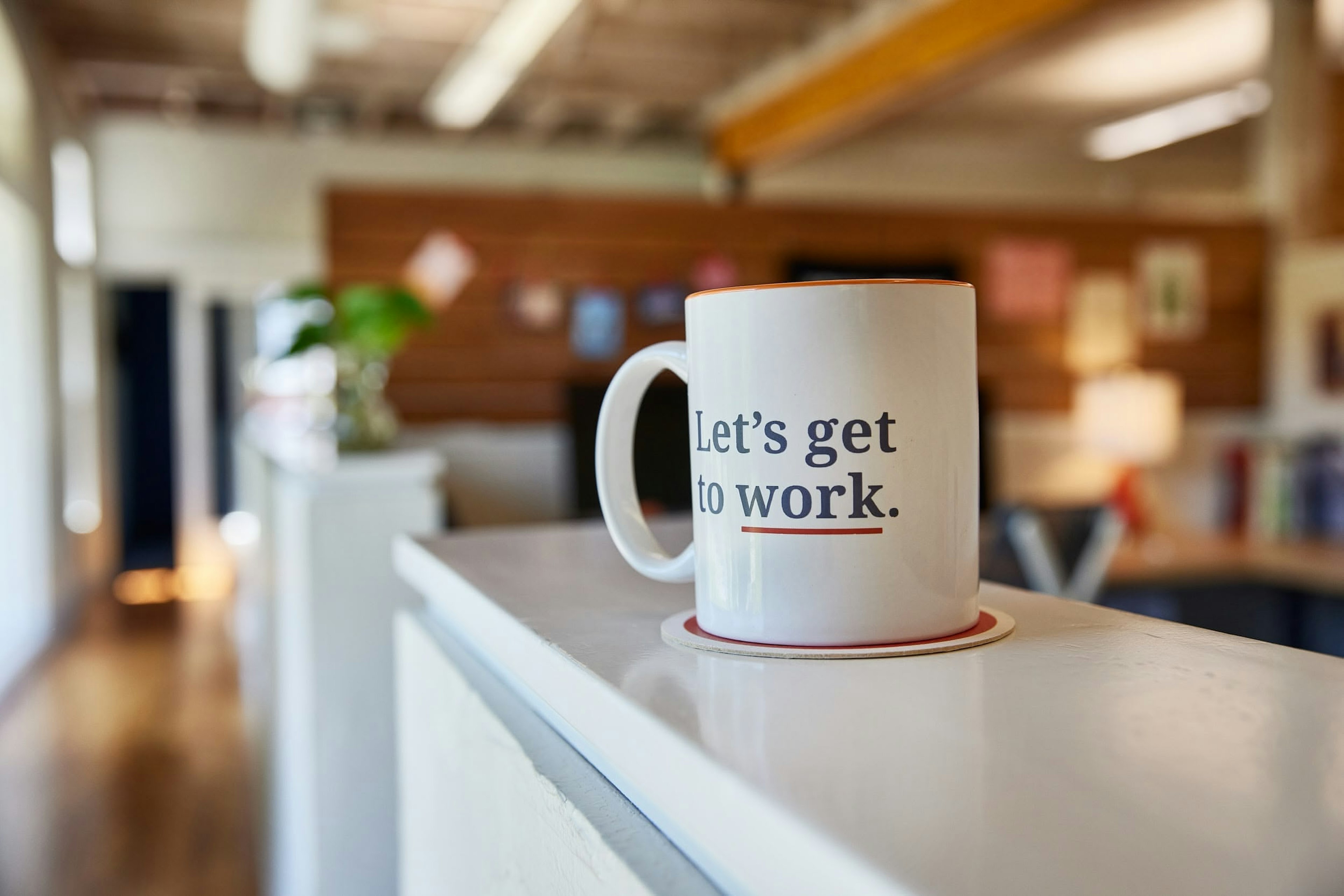 Mostly Serious team collaborating together around a table with laptops, notebooks, and coffee.