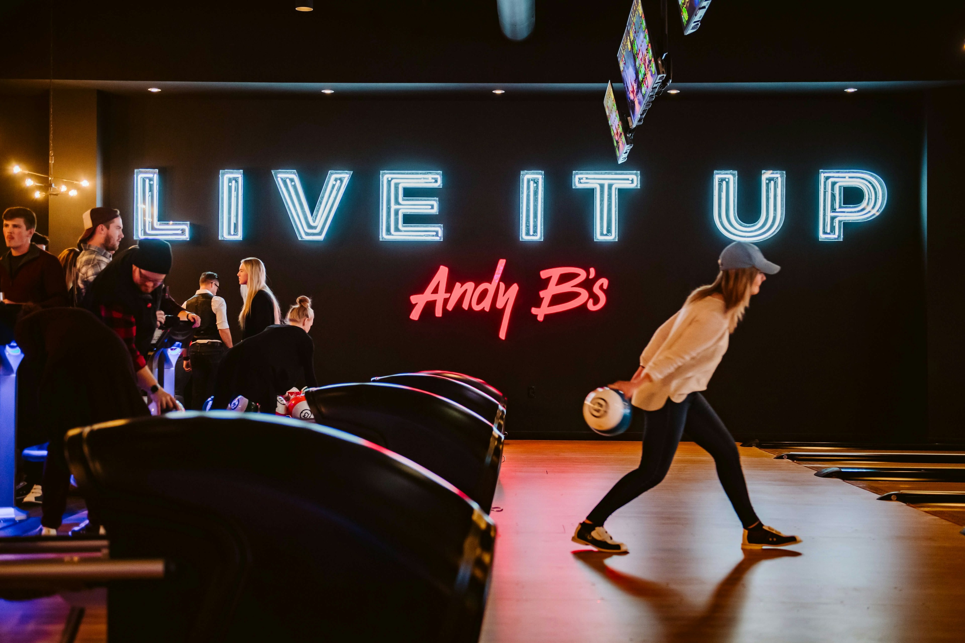 Homepage hero of the Andy B's Bowl Social website showing colorful bowling lanes, bold typography, and navigation for food, games, and parties.