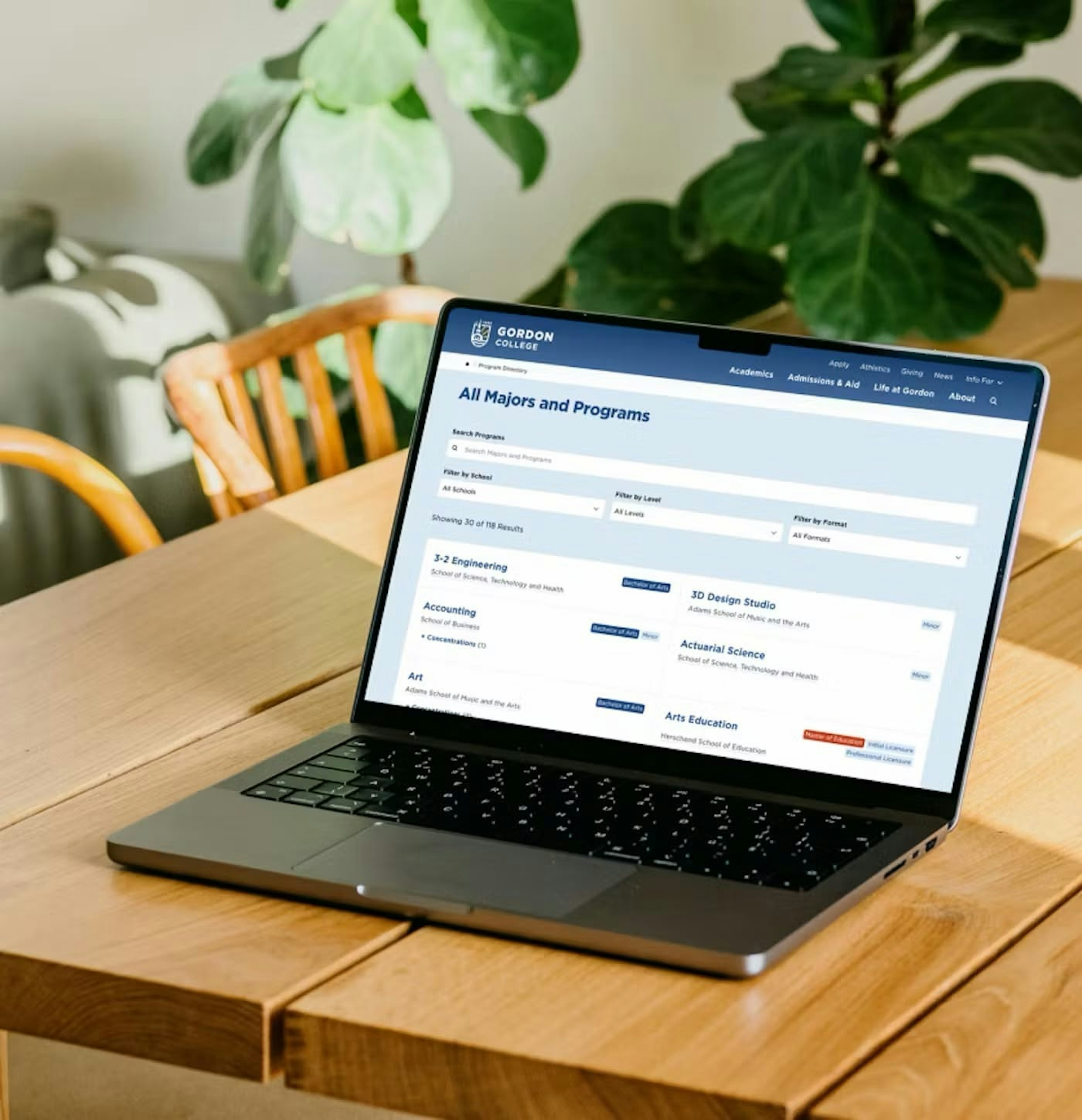 The redesigned Gordon College homepage on a desktop monitor with streamlined navigation and bold blue interface.